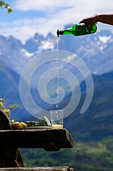 Pouring from high height of natural Asturian cider made fromÂ fermented apples, Asturian cabrales cow blue cheese with view on